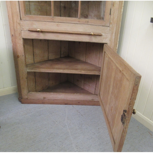 247 - A late Victorian pine corner cabinet with a dentil moulded cornice, over an astragal glazed door, a ... 