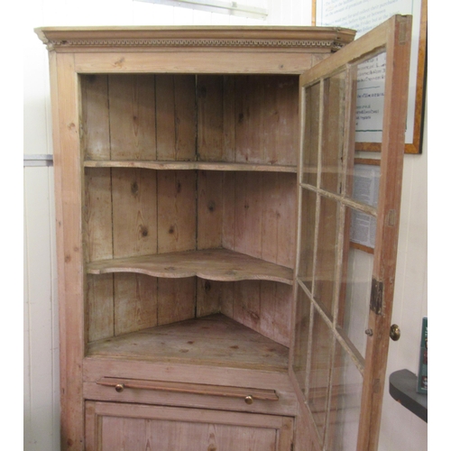 247 - A late Victorian pine corner cabinet with a dentil moulded cornice, over an astragal glazed door, a ... 