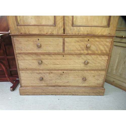 251 - An early Victorian satin mahogany linen press with a moulded cornice, over two panelled doors, enclo... 