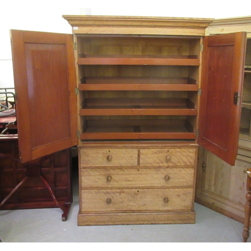 251 - An early Victorian satin mahogany linen press with a moulded cornice, over two panelled doors, enclo... 