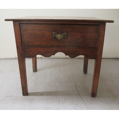 255 - An early 19thC oak lowboy with a single deep drawer and brass bail handle, over a fretworked apron, ... 