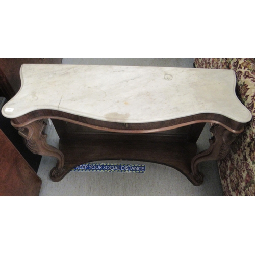 257 - A late Victorian walnut framed serpentine front serving table, the top set with a marble panel, rais... 