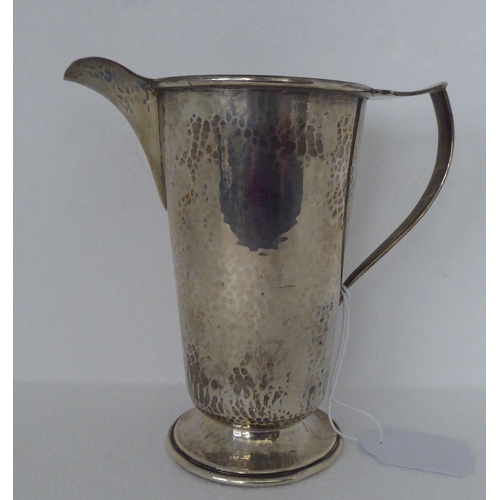 279 - A spot-hammered silver jug of tapered form, on a splayed pedestal foot  Birmingham 1931