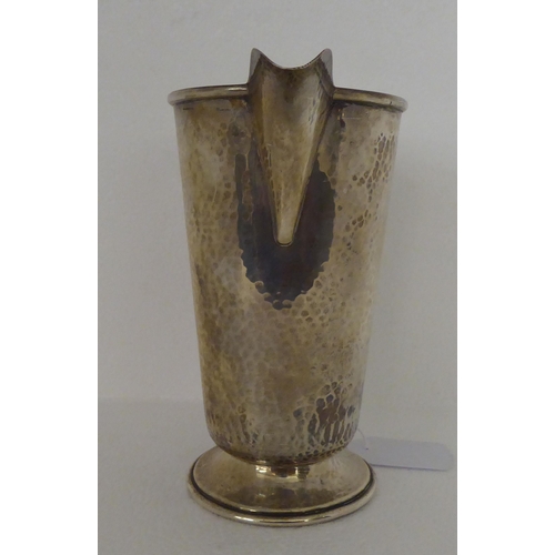 279 - A spot-hammered silver jug of tapered form, on a splayed pedestal foot  Birmingham 1931