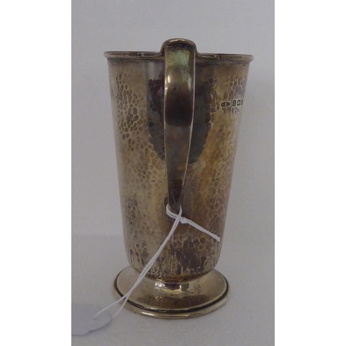 279 - A spot-hammered silver jug of tapered form, on a splayed pedestal foot  Birmingham 1931