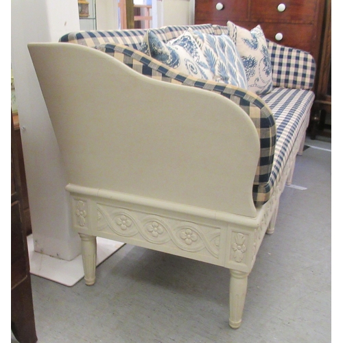 282 - An Ikea French style part carved cream coloured wooden framed settee with a level back and enclosed ... 