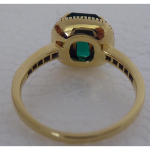 285 - A gold coloured metal claw set, simulated emerald and diamond ring 