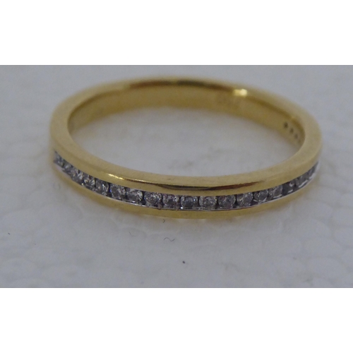 297 - A gold coloured metal, rubover set diamond half eternity ring  stamped 750 