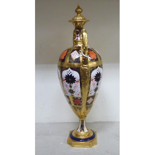 301 - A Royal Crown Derby china Imari pattern pedestal urn design vase with opposing handles  17