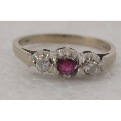 308 - An 18ct gold ring, set with a ruby, flanked by two diamonds