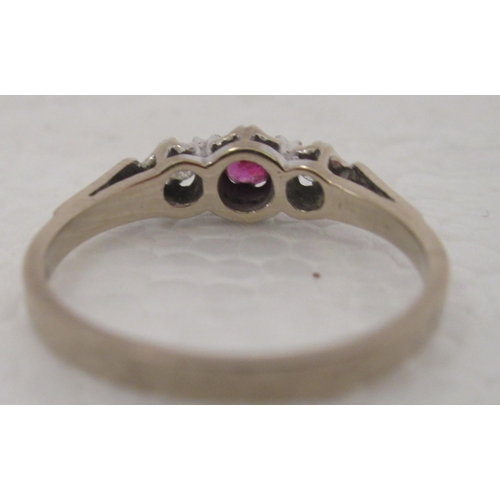 308 - An 18ct gold ring, set with a ruby, flanked by two diamonds