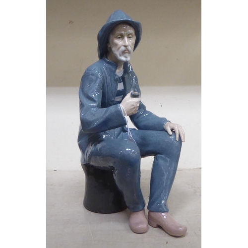 317 - A Nao porcelain figure, a seated gentleman smoking a pipe  15