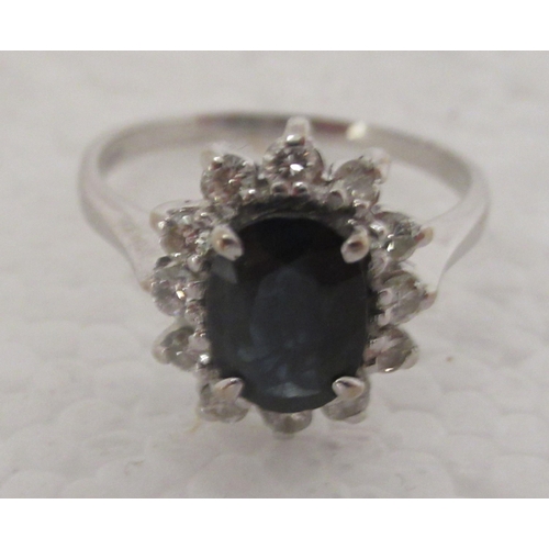 318 - An 18ct white gold ring, set with a central sapphire, surrounded by diamonds 