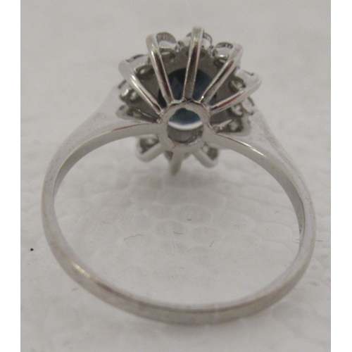 318 - An 18ct white gold ring, set with a central sapphire, surrounded by diamonds 