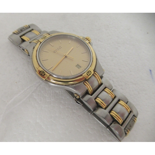 325 - A Gucci 9040m wristwatch, faced by a baton dial with a date aperture