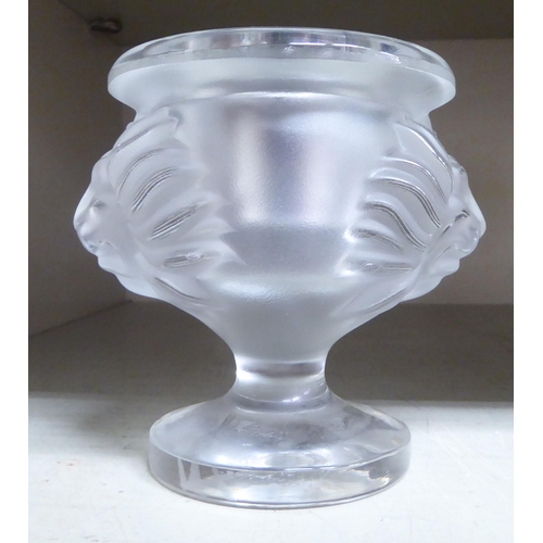 378 - A modern Lalique glass pedestal candle holder, fashioned as an urn with opposing lion mask ornament ... 