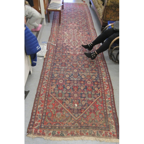 103 - A Persian runner, decorated with floral motifs, on a red and blue ground  196