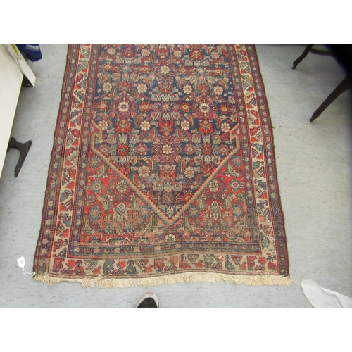 103 - A Persian runner, decorated with floral motifs, on a red and blue ground  196