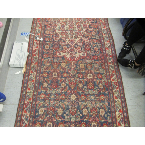 103 - A Persian runner, decorated with floral motifs, on a red and blue ground  196