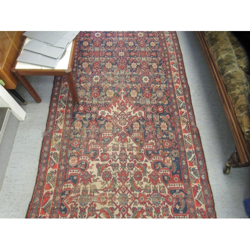 103 - A Persian runner, decorated with floral motifs, on a red and blue ground  196