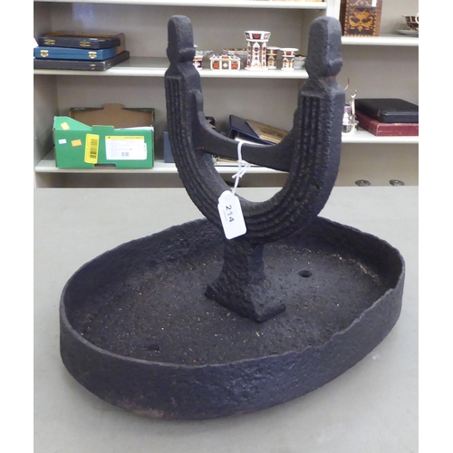 214 - A 19thC black painted cast iron boot scraper, on an oval tray base 