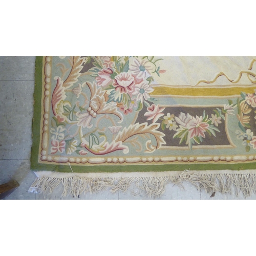 219 - A crewel worked rug, decorated in pastel colours with floral designs  60