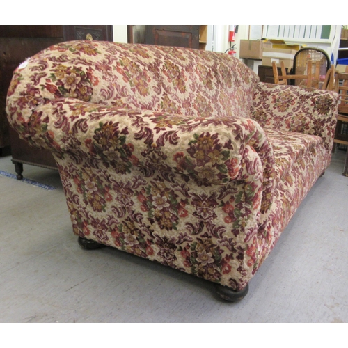 236 - A late Victorian three person Chesterfield with floral fabric upholstery, raised on mahogany turned ... 