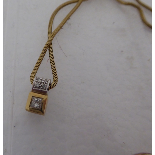 260 - A bi-coloured gold coloured metal and cubic zirconia set pendant, on a fine, flexible link neckchain... 