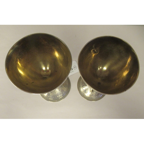 15 - A pair of late 19thC silver Gothic inspired goblets with uniformly engraved decoration, each ovoid s... 