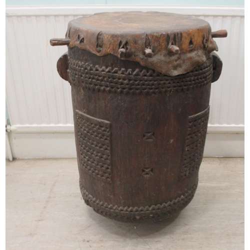 62 - An early 20thC North African tribal drum of barrel design with chip carved ornament and a stretched ... 