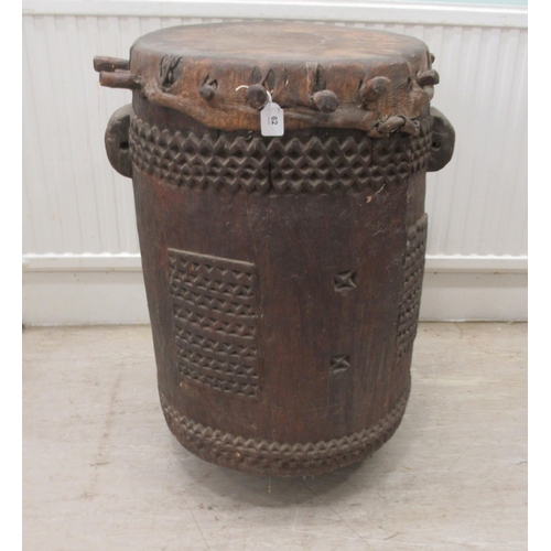 62 - An early 20thC North African tribal drum of barrel design with chip carved ornament and a stretched ... 