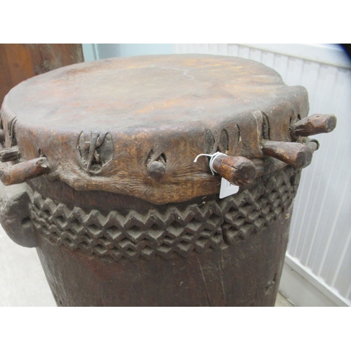 62 - An early 20thC North African tribal drum of barrel design with chip carved ornament and a stretched ... 