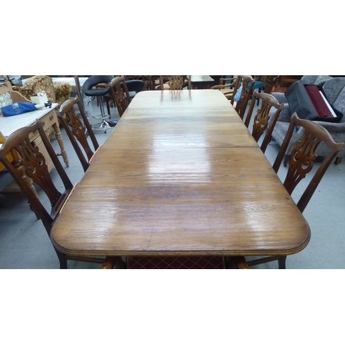 165 - A modern reproduction of a Georgian oak twin pedestal dining table, the top with a moulded edge and ... 