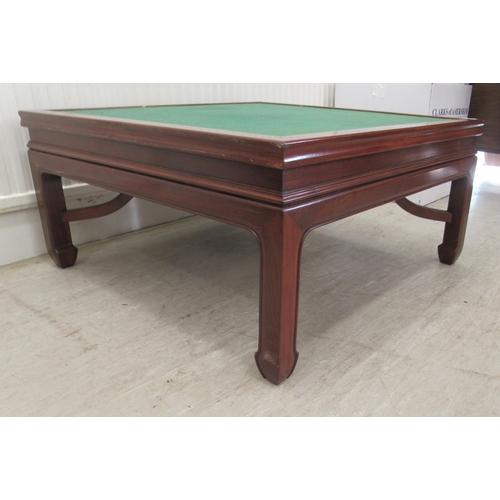 110 - A Chinese rosewood coffee table with a baize top, raised on block legs  17