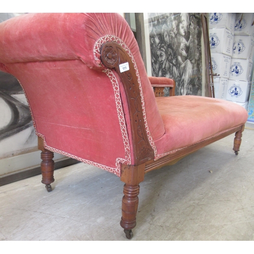 111 - A late Victorian walnut framed chaise longue, upholstered in a red fabric, raised on turned legs