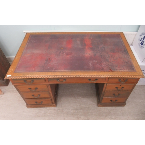 113 - A mid 20thC mahogany nine drawer, twin pedestal desk, on a plinth  30