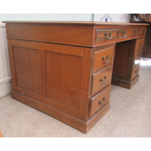 113 - A mid 20thC mahogany nine drawer, twin pedestal desk, on a plinth  30