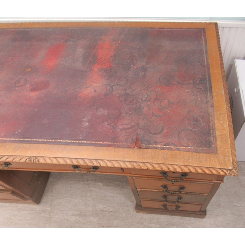 113 - A mid 20thC mahogany nine drawer, twin pedestal desk, on a plinth  30