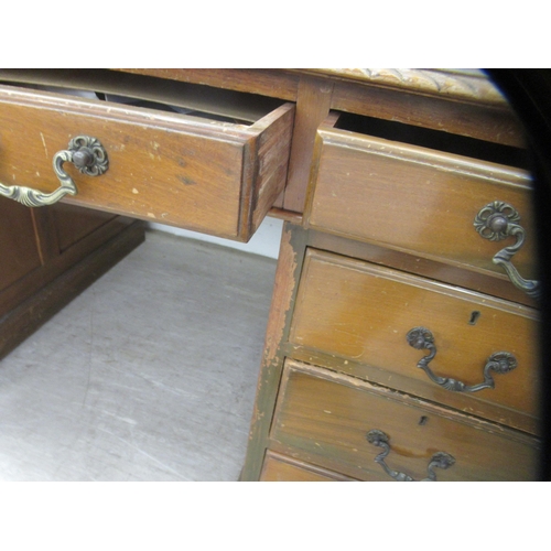 113 - A mid 20thC mahogany nine drawer, twin pedestal desk, on a plinth  30