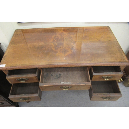 16 - A late 19th/early 20thC crossbanded mahogany and walnut, five drawer kneehole desk, raised on cabrio... 