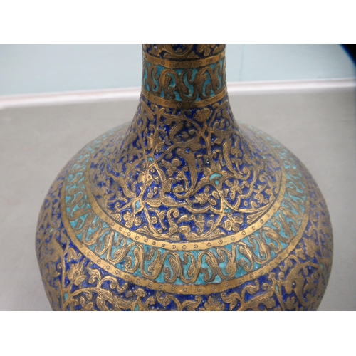 184 - A 20thC Middle Eastern enamelled and brass vase with a tall neck and bulbous body, on a pedestal foo... 