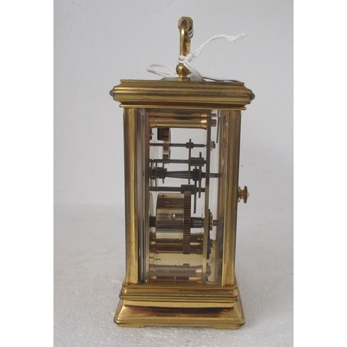 200 - A modern lacquered brass cased carriage timepiece with bevelled glass panels and a folding top handl... 