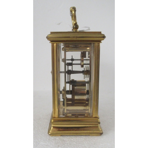 200 - A modern lacquered brass cased carriage timepiece with bevelled glass panels and a folding top handl... 