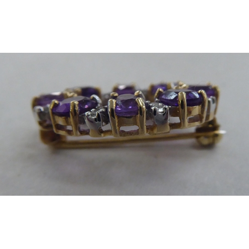 209 - A 9ct gold brooch, set with alternating amethysts and diamonds