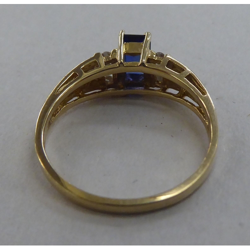 214 - A 10k gold ring, set with a central sapphire, flanked by six diamonds