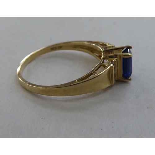 214 - A 10k gold ring, set with a central sapphire, flanked by six diamonds