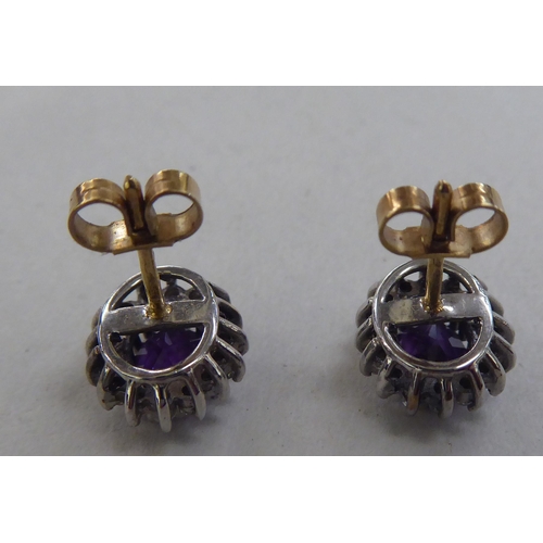 219 - A pair of 9ct gold cluster earrings, each set with a central amethyst, surrounded by diamonds