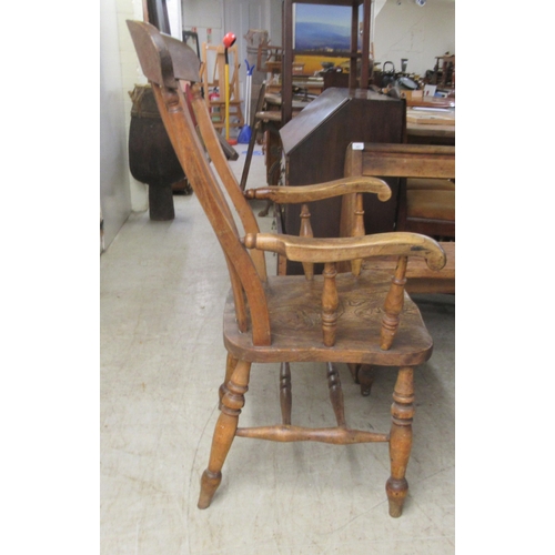 282 - A 19thC Windsor beech and elm framed, lath back, open arm chair, the solid seat raised on turned leg... 