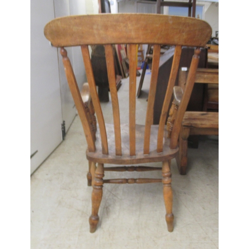 282 - A 19thC Windsor beech and elm framed, lath back, open arm chair, the solid seat raised on turned leg... 