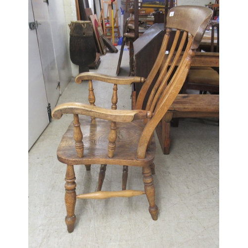 282 - A 19thC Windsor beech and elm framed, lath back, open arm chair, the solid seat raised on turned leg... 